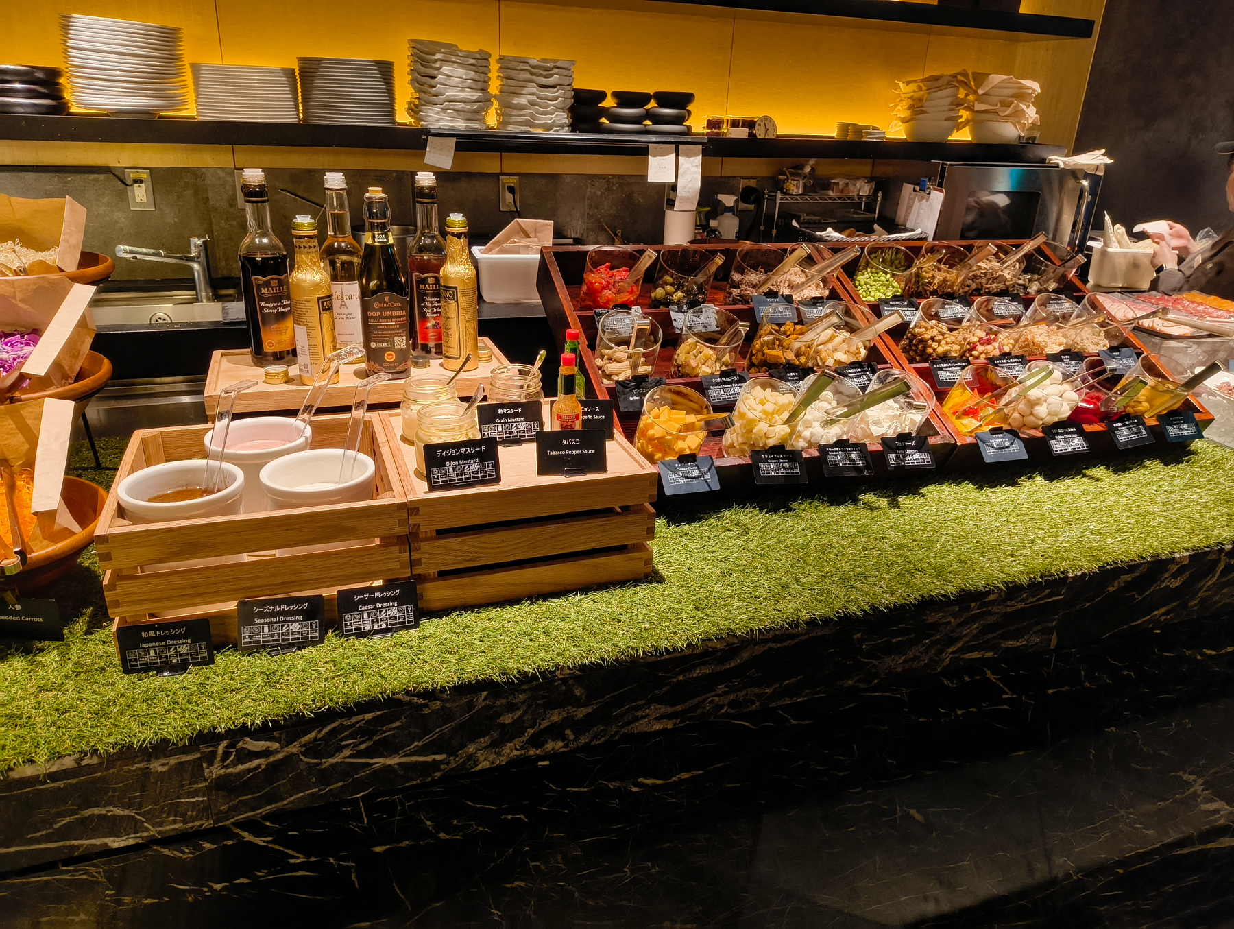 Auto-generated description: レストランのカウンターに、さまざまな調味料と食品が並んでいる。