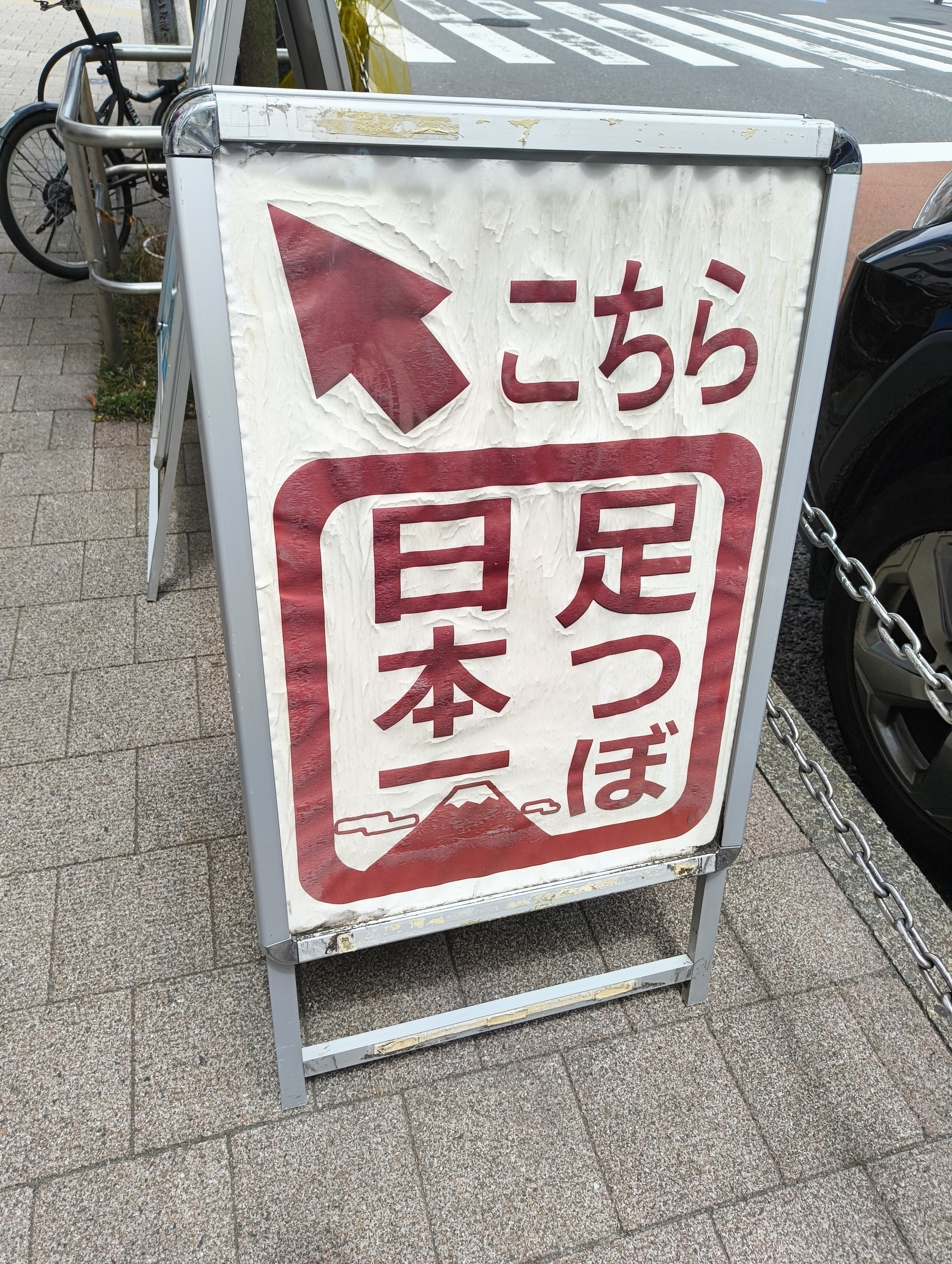Auto-generated description: こちらの看板には「足つぼ日本一」と矢印が描かれています。