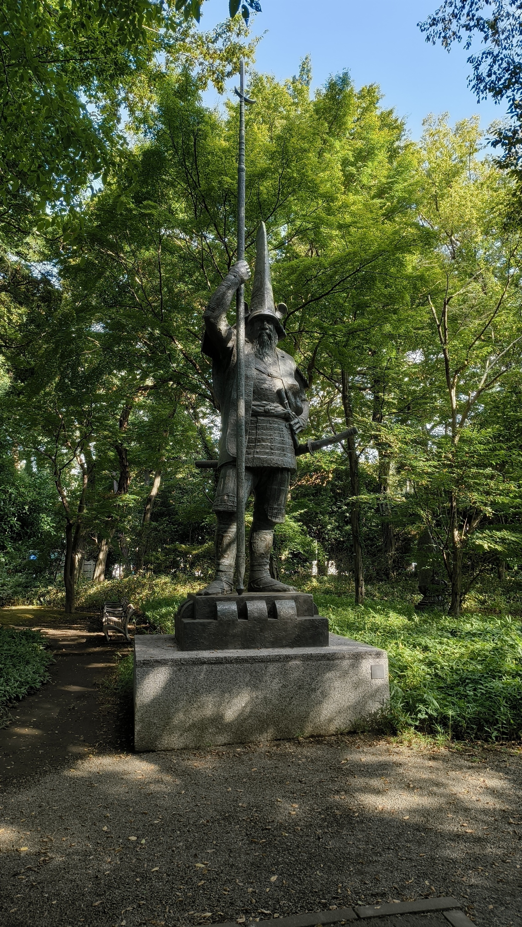 Auto-generated description: 緑豊かな公園に武士の像が立っています。