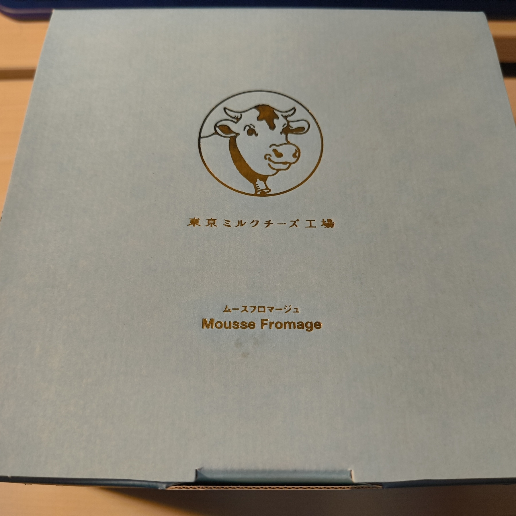 Auto-generated description: 青色の箱に東京ミルクチーズ工場のロゴと「ムースフロマージュ Mousse Fromage」の文字が印刷されています。
