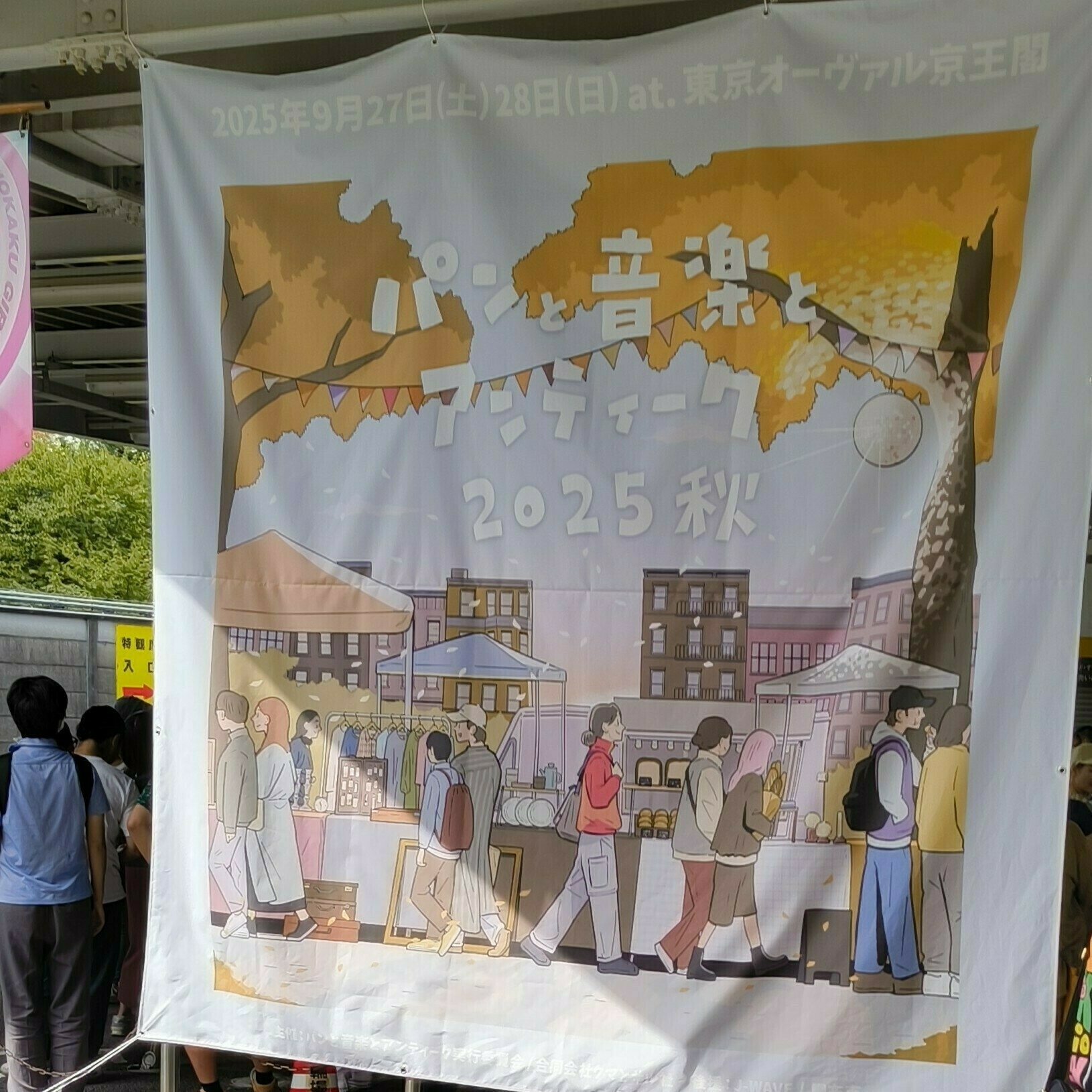 Auto-generated description: 2025年秋の「パンと音楽とアンティーク」イベントを告知する看板が掛けられています。