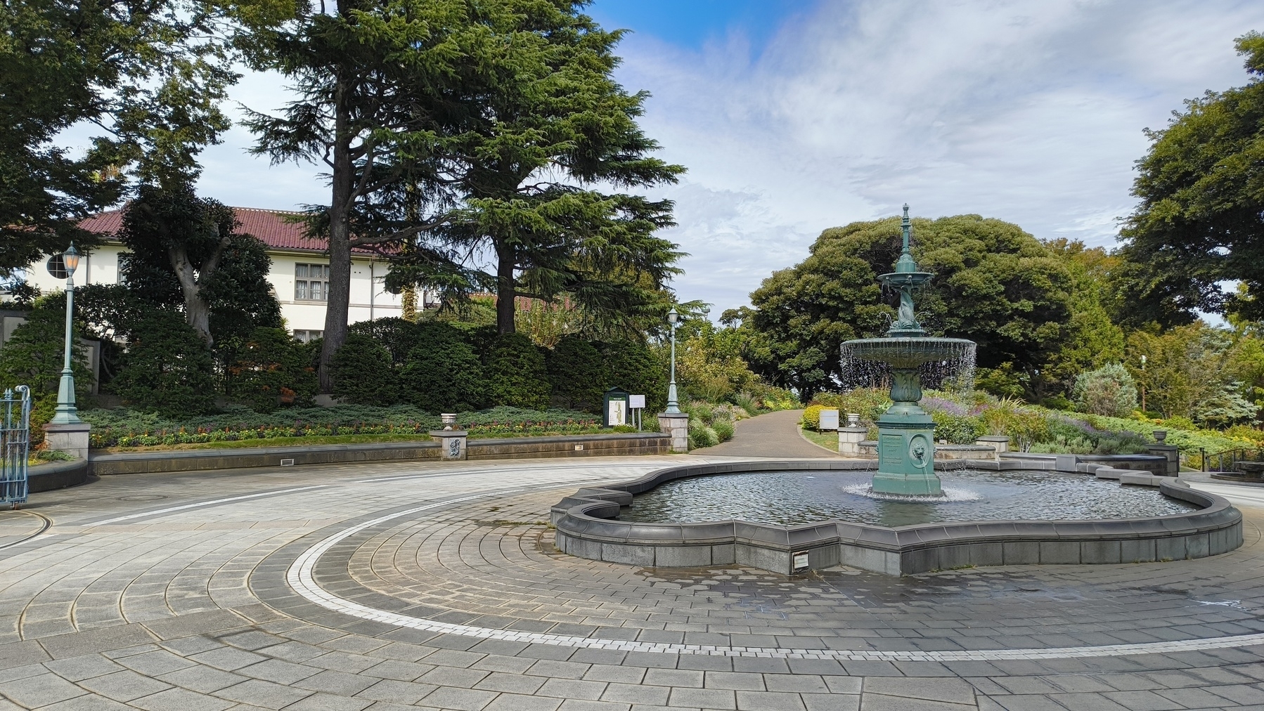 Auto-generated description: 噴水や緑に囲まれた公園の風景が広がっています。