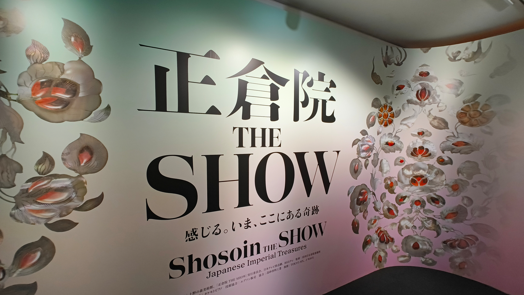 Auto-generated description: 正倉院の展示を紹介する壁に花のイラストが描かれています。