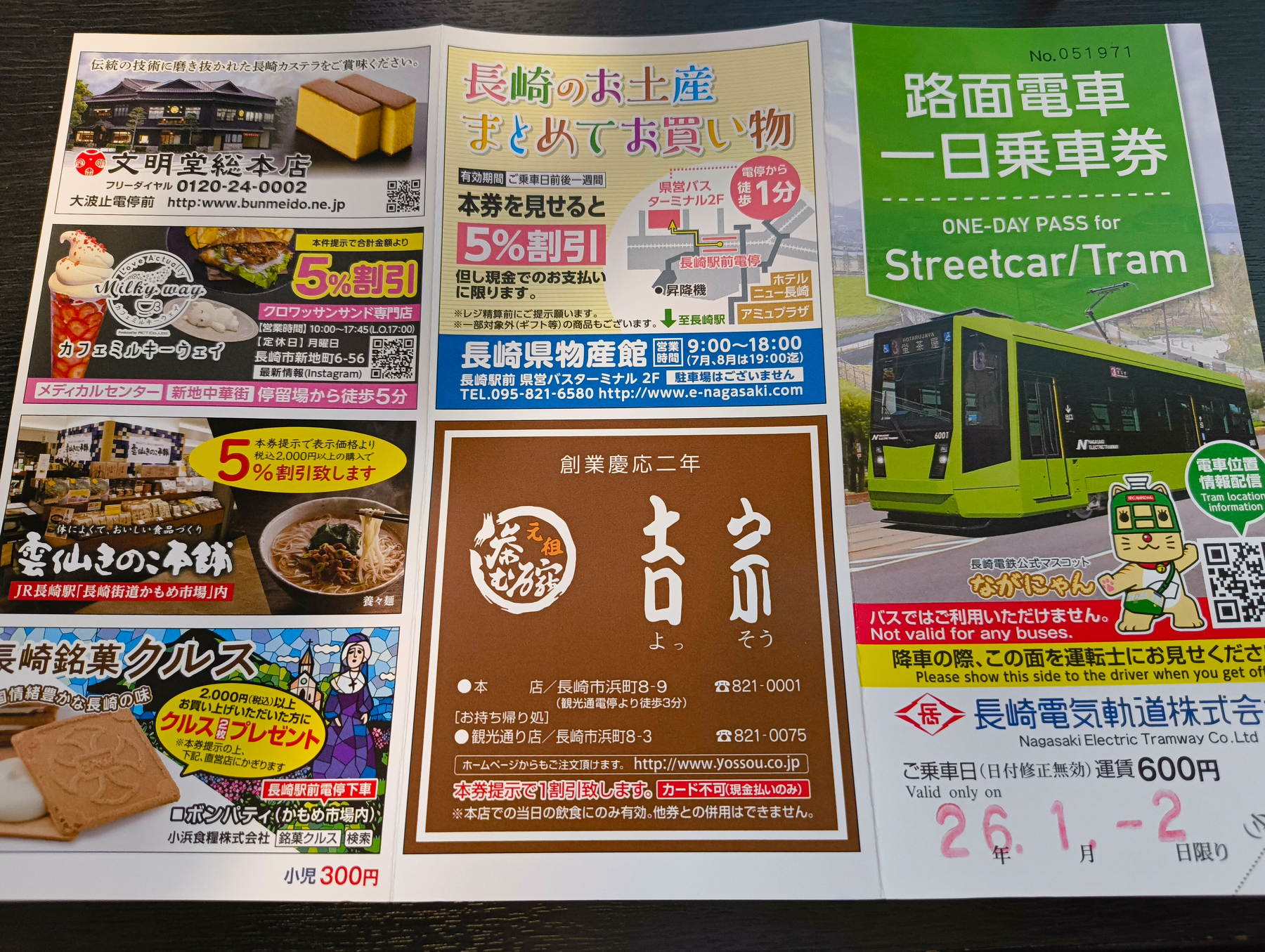 路面電車の一日乗車券や地域の特産品情報が載った広告とパンフレットが並んでいます。