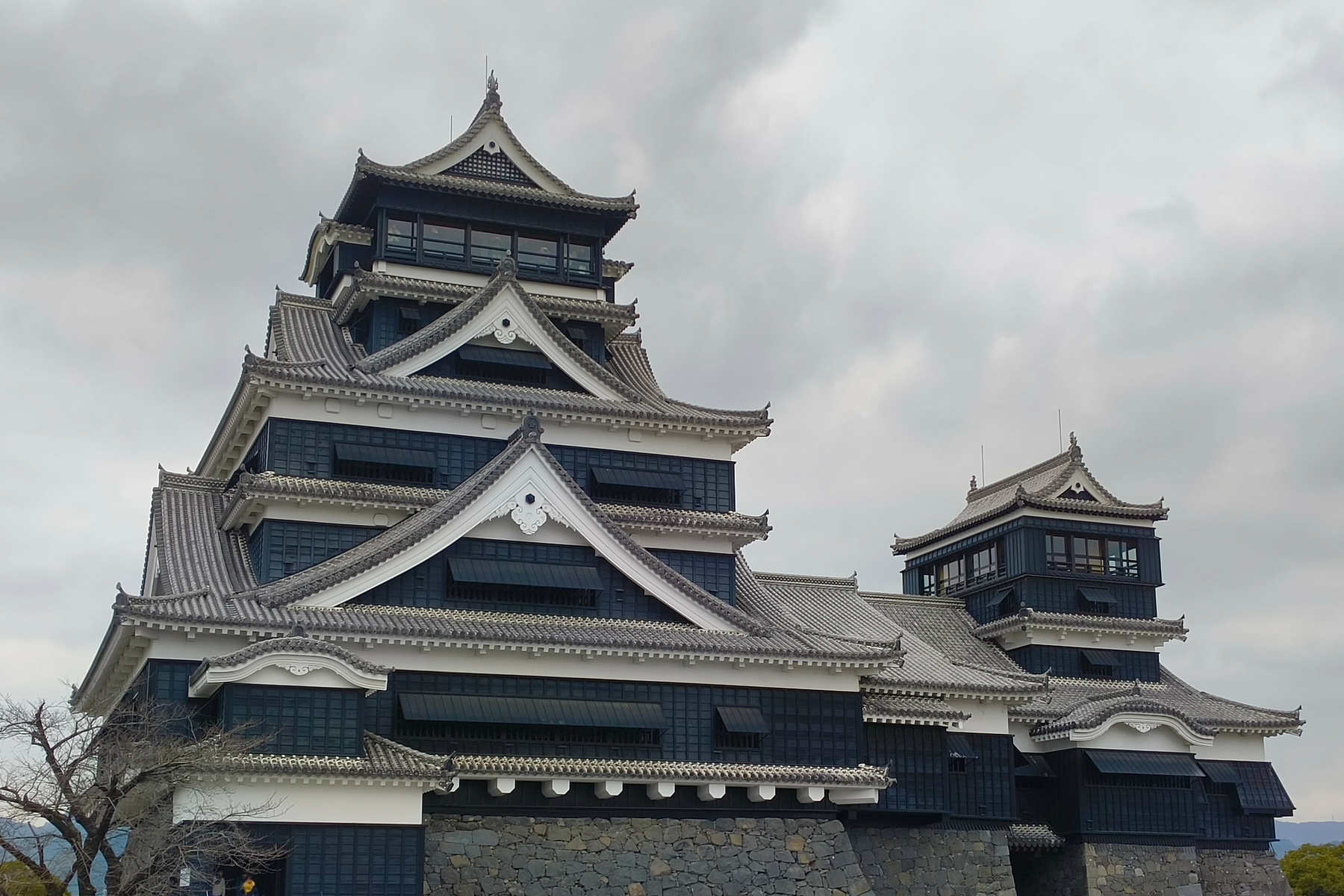 Auto-generated description: 日本の伝統的な建築様式の城が曇り空の下に立っています。