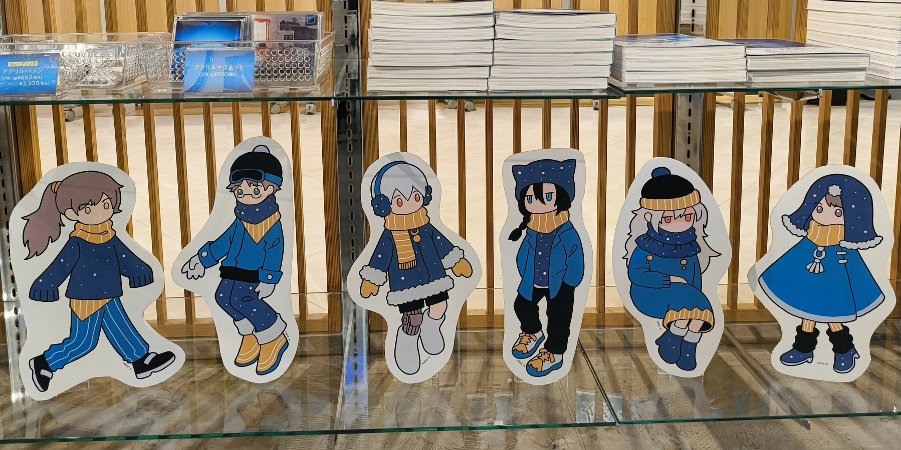 Auto-generated description: 棚に冬の装いをしたキャラクターのイラストカードが並んでいます。