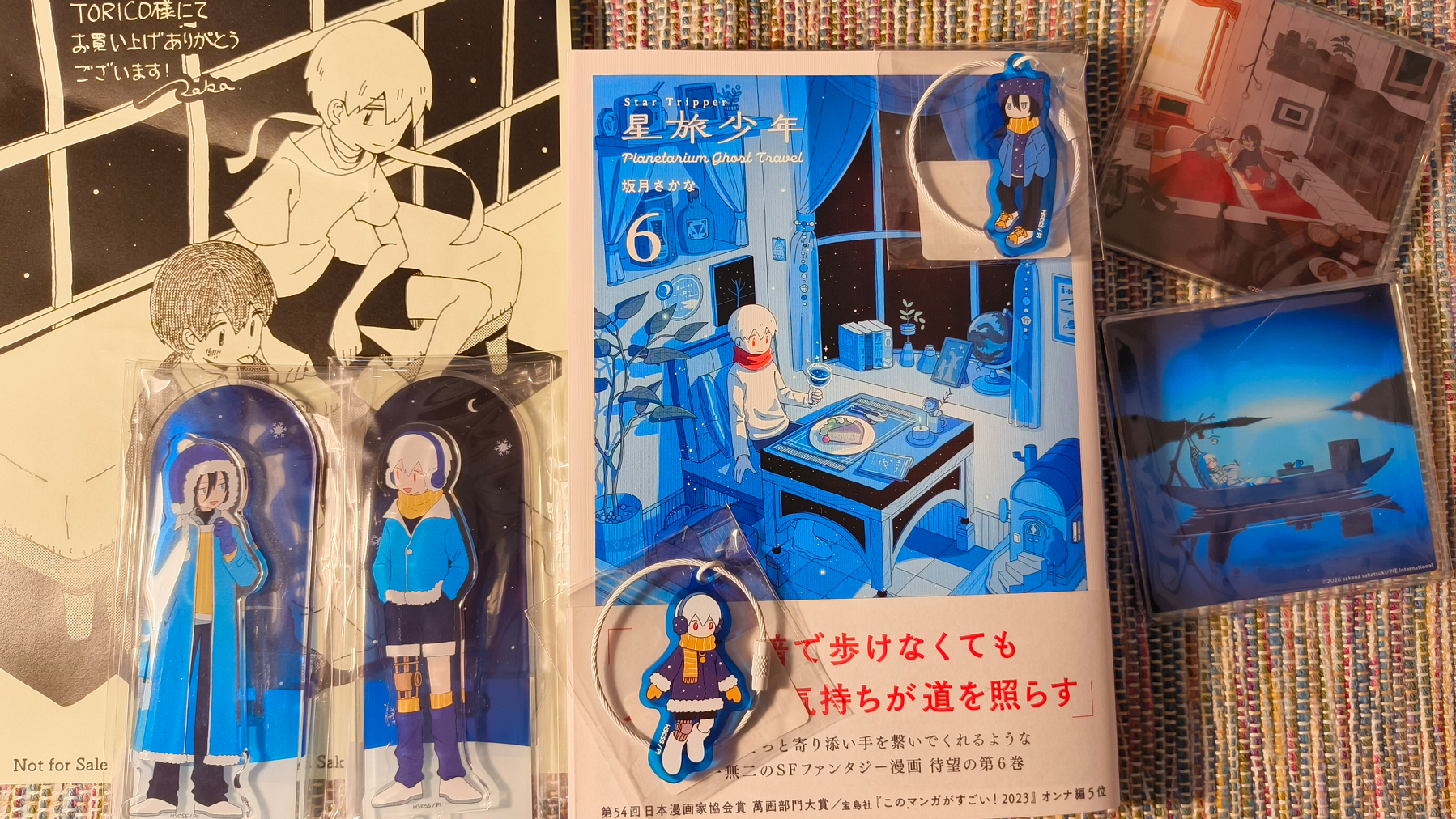 Auto-generated description: 漫画やアニメのキャラクターグッズが並べられたディスプレイ。