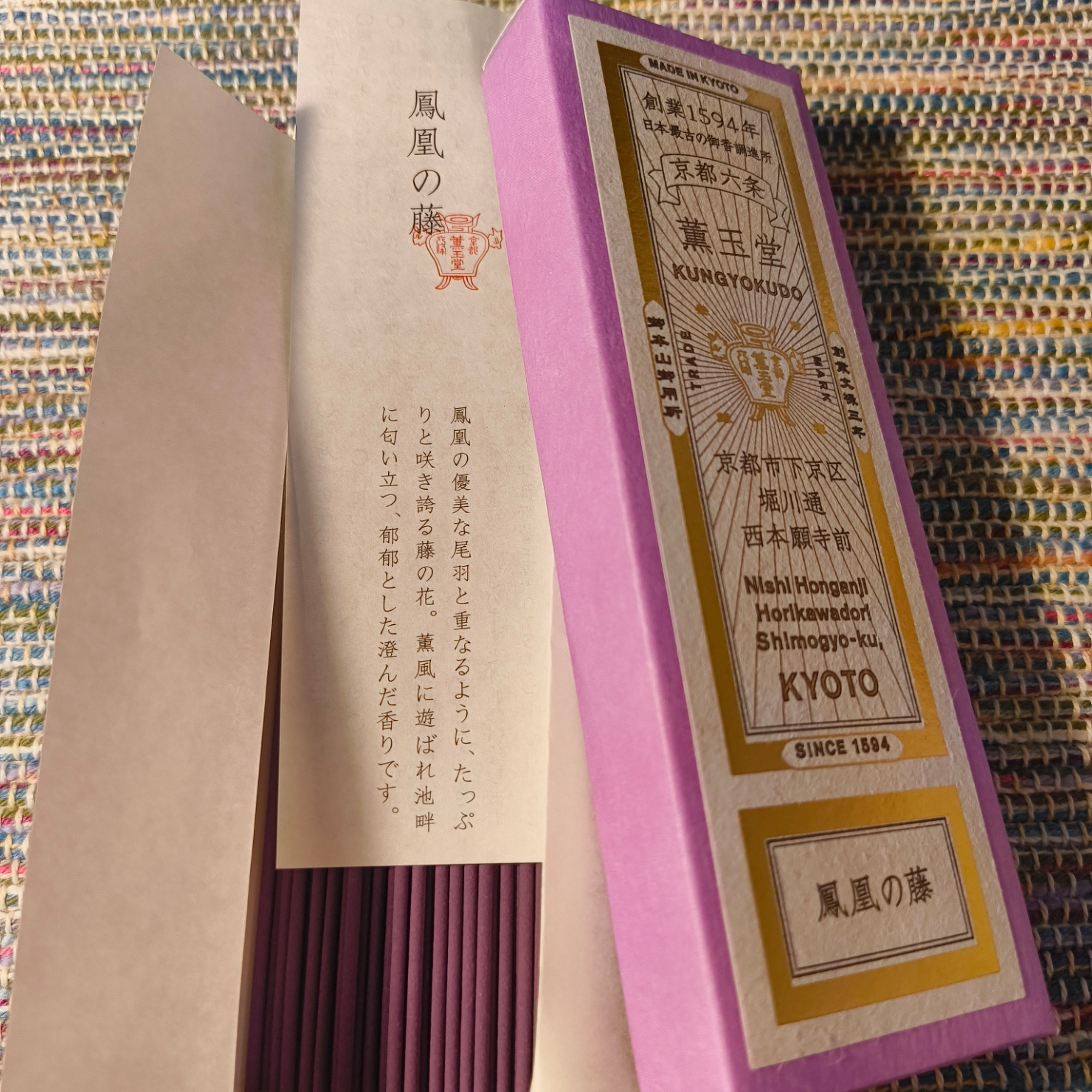 紫色の箱に入ったお香が和風の敷物の上に置かれている。