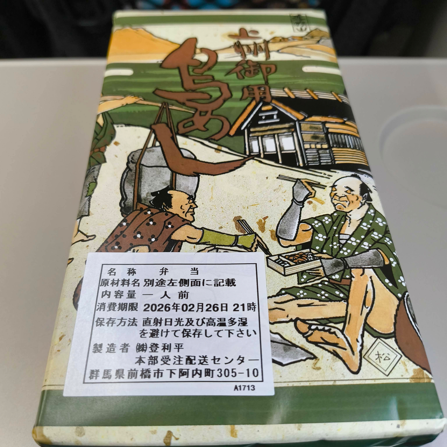 Auto-generated description: 日本の伝統的な服装をした2人が食事を楽しんでいる様子が描かれた鳥めしのパッケージです。
